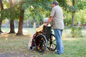 Rollstuhlfahrerin mit Betreuer im Park